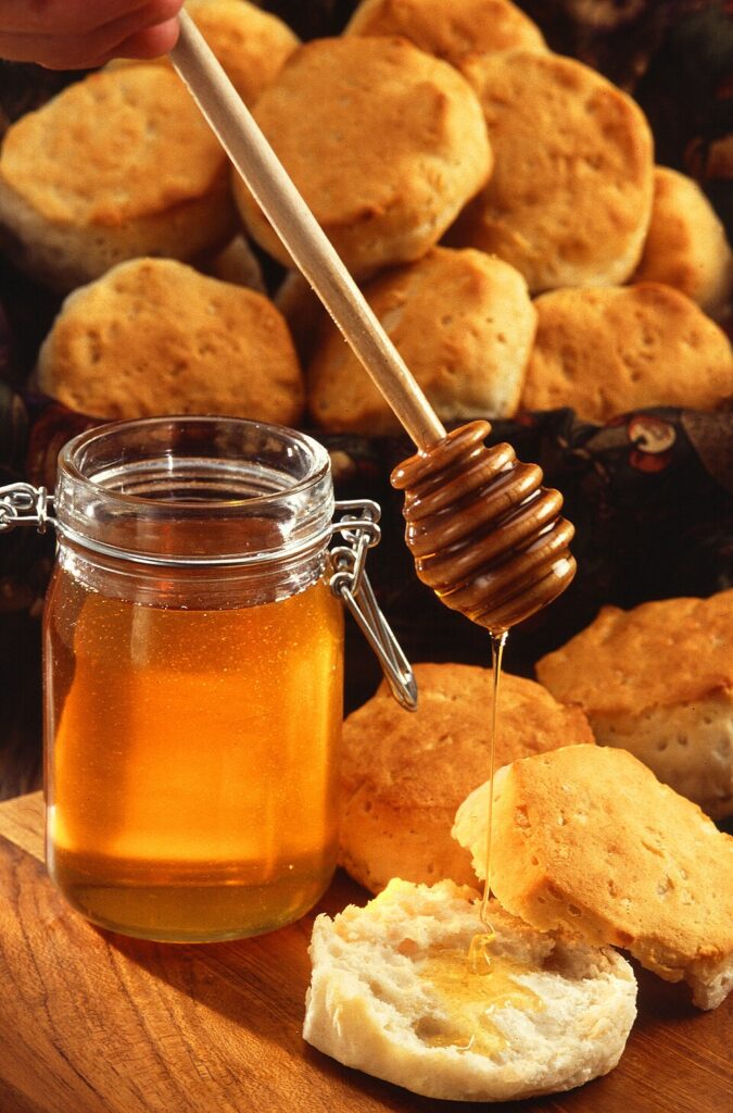 Jar of raw honey being drizzled with a honey dipper, illustrating whether honey is kosher