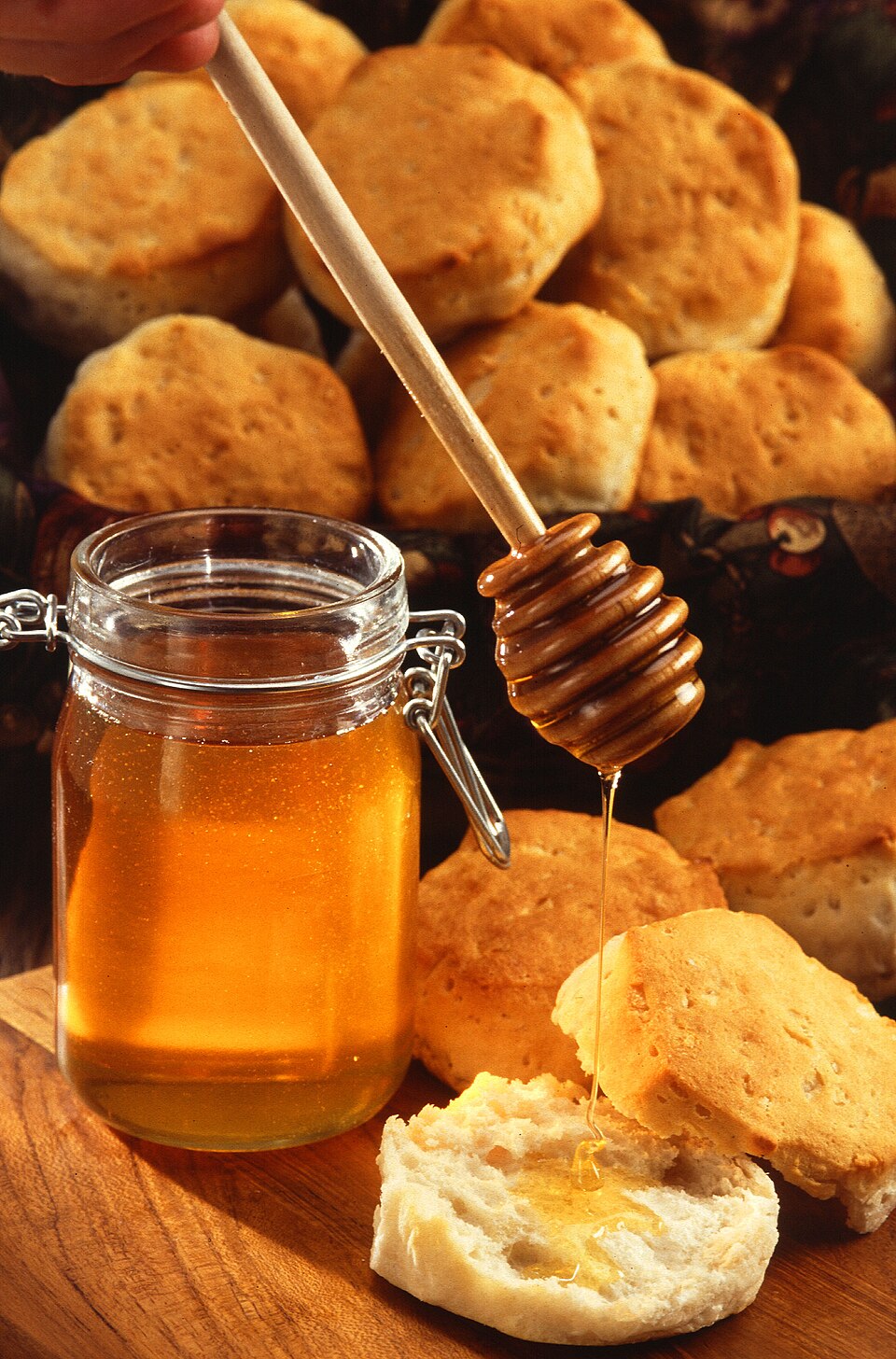Jar of raw honey being drizzled with a honey dipper, illustrating whether honey is kosher